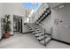 Grand staircase with modern metal railings and open risers, complemented by a unique textured wall and natural light at 5 Highland Cove Ln, Henderson, NV 89011