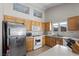 Cozy kitchen with stainless steel refrigerator, white appliances, light wood cabinets and charming nautical themed artwork at 5117 Axbridge Ct, North Las Vegas, NV 89031