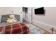 Charming bedroom with a grey bed and a red blanket and a TV on the wall at 5131 Moose Falls Dr, Las Vegas, NV 89141