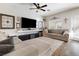 Cozy living room with large screen television, ceiling fan, and comfortable seating area at 5131 Moose Falls Dr, Las Vegas, NV 89141