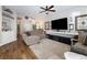 Inviting living room with a plush rug, modern ceiling fan, and large screen television at 5131 Moose Falls Dr, Las Vegas, NV 89141