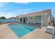 A clear blue pool surrounded by a concrete patio with a covered patio and a blue privacy wall at 519 Landra Ln, Henderson, NV 89015
