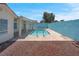A clear blue pool surrounded by a concrete patio with a covered patio, and a red rock landscape at 519 Landra Ln, Henderson, NV 89015