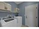 Laundry room with washer, dryer, built-in cabinets, and a door leading outside at 599 Wounded Star Ave, Las Vegas, NV 89178