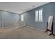 Loft area with carpet flooring, natural light, and a railing overlooking the staircase at 599 Wounded Star Ave, Las Vegas, NV 89178