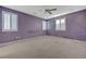 Large main bedroom with multiple windows, grey carpet, and a ceiling fan at 599 Wounded Star Ave, Las Vegas, NV 89178