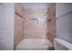 Bathroom featuring a tub with light brown marble-look tile surround and decorative glass tile border at 6006 Vegas Dr, Las Vegas, NV 89108