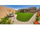 Lush backyard featuring artificial turf, desert landscape, and patio lounge area at 6098 Avery Pointe St, Las Vegas, NV 89166