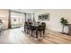 Bright dining room features a modern light fixture, wood floors, and sliding glass doors to the backyard at 6098 Avery Pointe St, Las Vegas, NV 89166