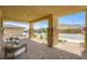 Inviting covered porch featuring stone pillars, brick flooring, comfortable seating and open views of the community at 6098 Avery Pointe St, Las Vegas, NV 89166