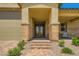 Charming front porch featuring stone pillars, brick walkway, with inviting seating, and desert landscaping at 6098 Avery Pointe St, Las Vegas, NV 89166