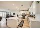 Open kitchen featuring an island with seating, modern stainless-steel appliances, and pristine white cabinetry at 6098 Avery Pointe St, Las Vegas, NV 89166