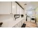 Well-lit laundry room boasting ample storage, quartz counters, and modern appliances at 6098 Avery Pointe St, Las Vegas, NV 89166