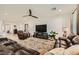 Spacious living room with modern ceiling fan, plush leather seating, and a cozy fireplace at 6098 Avery Pointe St, Las Vegas, NV 89166