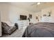 Bedroom with a cozy armchair, large TV, and dresser providing ample storage and a comfortable living space at 6098 Avery Pointe St, Las Vegas, NV 89166