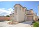 Two-story home featuring a tile roof, dual garages, and desert landscaping enhancing curb appeal at 6098 Darkfeather Way, Las Vegas, NV 89139