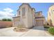 Two-story home featuring dual garages, desert landscaping, and stucco exterior at 6098 Darkfeather Way, Las Vegas, NV 89139