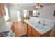Kitchen area showcasing laminate floors, a double sink, and cabinetry at 6098 Darkfeather Way, Las Vegas, NV 89139