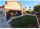 Spacious backyard featuring a covered patio with lounge area, well-maintained lawn, and a charming garden at 6746 Shelter Ln, Las Vegas, NV 89103