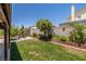 Lush backyard featuring a well-maintained lawn, mature trees, and blooming flowers at 6746 Shelter Ln, Las Vegas, NV 89103