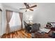 Bright bedroom featuring hardwood floors, a ceiling fan, and a wooden desk, ideal for a home office at 6746 Shelter Ln, Las Vegas, NV 89103
