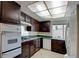 A kitchen featuring dark wood cabinets, tile flooring, and updated appliances at 6822 Garden Grove Ave, Las Vegas, NV 89103