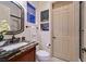 Updated bathroom featuring granite countertops, a modern sink, a window, and a glass-enclosed shower at 69 Tapadero Ln, Las Vegas, NV 89135