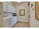 Functional laundry room with ample cabinet space, a sink, and direct access to the backyard at 69 Tapadero Ln, Las Vegas, NV 89135