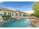 A luxurious pool with rock features and lush landscaping complements this home's outdoor space at 69 Tapadero Ln, Las Vegas, NV 89135