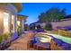 Stunning backyard view showcasing a custom pool, spa, and lush landscaping at dusk at 69 Tapadero Ln, Las Vegas, NV 89135