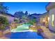 Custom pool with a beautiful rock waterfall feature and lush tropical landscaping at 69 Tapadero Ln, Las Vegas, NV 89135