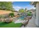 Beautiful backyard pool featuring stone accents, waterfall, and tropical landscaping at 69 Tapadero Ln, Las Vegas, NV 89135