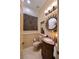 Stylish powder room featuring granite countertops, travertine walls, and decorative fixtures at 69 Tapadero Ln, Las Vegas, NV 89135