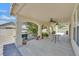 Covered back patio with ceiling fans, arched supports, outdoor grill, table, and view of the backyard at 6920 Haven Hollow Ave, Las Vegas, NV 89130