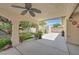 Covered back patio with ceiling fan, a large backyard featuring artificial grass, a shed, and beautiful landscaping at 6920 Haven Hollow Ave, Las Vegas, NV 89130