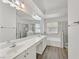 Modern bathroom with double sinks, a tub, a glass shower and a sleek white vanity at 6920 Haven Hollow Ave, Las Vegas, NV 89130