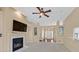 Comfortable living room with a fireplace and a large screen tv, a ceiling fan, and views of other rooms at 6920 Haven Hollow Ave, Las Vegas, NV 89130