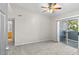 Bright bedroom featuring neutral carpet, sliding glass door, and ceiling fan with light fixture at 6955 N Durango Dr # 2054, Las Vegas, NV 89149