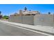 The backyard features block wall fencing, an ornate gate, and a spacious area for parking at 7019 Shadow Crest Dr, Las Vegas, NV 89119