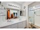 Bathroom featuring a double vanity, a large mirror, and a glass-enclosed shower at 7019 Shadow Crest Dr, Las Vegas, NV 89119