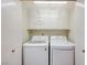 This laundry room features a washer and dryer set in a closet with shelving at 7019 Shadow Crest Dr, Las Vegas, NV 89119