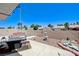 This patio features a bench, small fountain, fire pit table and desert landscaping at 7019 Shadow Crest Dr, Las Vegas, NV 89119