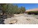 Expansive backyard with stone accents, desert landscaping, and mature trees, offering privacy at 710 Tomahawk Ct, Pahrump, NV 89060
