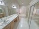 Bathroom featuring double sinks, a jetted tub, a shower, and a mirrored closet at 710 Tomahawk Ct, Pahrump, NV 89060