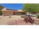Charming single-story home featuring mature landscaping, desert rock, and solar panels on the roof at 710 Tomahawk Ct, Pahrump, NV 89060