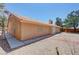 Back exterior view of a desert home showcasing a tiled roof, screened patio, and landscaped yard at 710 Tomahawk Ct, Pahrump, NV 89060