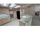 Charming kitchen features tile floors, light wood cabinets, and a breakfast bar overlooking the living room at 710 Tomahawk Ct, Pahrump, NV 89060