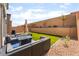 Private backyard featuring artificial grass, rock landscaping and a cozy seating area with a fire table at 7211 Alabaster Peak St, Las Vegas, NV 89166