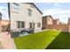 Landscaped backyard featuring green artificial turf, an outdoor seating area, perfect for relaxation at 7211 Alabaster Peak St, Las Vegas, NV 89166
