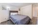 Comfortable bedroom with a wooden bed frame, soft gray bedding, and closet for storage at 7211 Alabaster Peak St, Las Vegas, NV 89166